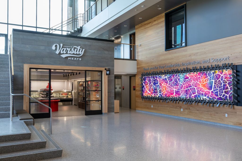 The MSABD lobby is a bright open space and features the storefront to Bucky’s Varsity Meats and the colorful backlit donor recognition wall.