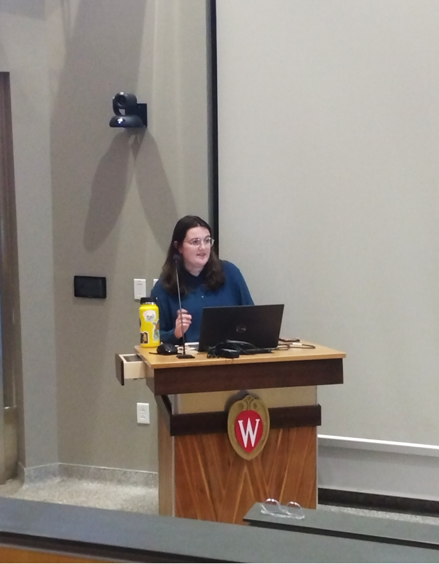 Margaret Costello speaks from the podium at her defense seminar presentation.